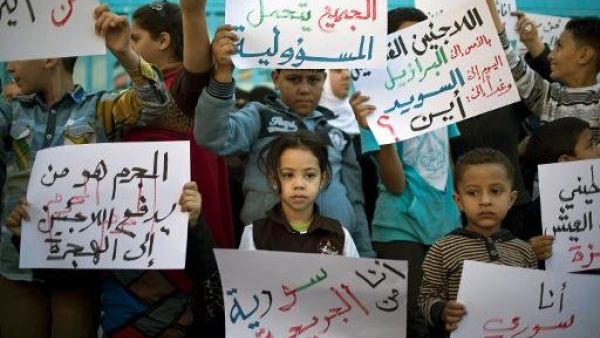 اطفال فلسطينيون فروا مع اسرهم من سوريا يتظاهرون امام مكاتب الانروا في غزة
