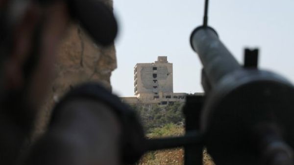 مقاتل من الجيش الحر يصوب سلاحه باتجاه مستشفى الكندي الذي تسيطر عليه قوات النظام في حلب
