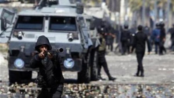 شرطي يطلق غازا مسيلا للدموع على محتجين مناهضين للرئيس المصري محمد مرسي أثناء اشتباكات بين الطرفين في بورسعيد
