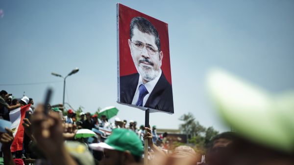 Egyptian Islamist groups led by the ruling Muslim Brotherhood shout slogans during a demonstration to mark the upcoming one year anniversary since President Mohamed Morsi (portrait) was elected, on June 21, 2013 in Cairo. (Source AFP/GIANLUIGI GUERCIA)