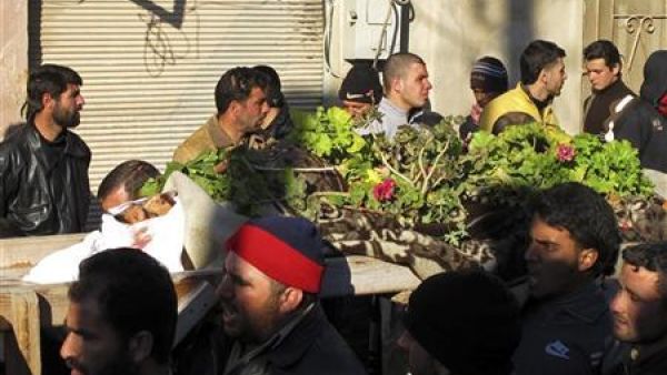رجال يشيعون جنازة خمسة مدنيين قتلوا جراء قصف الجيش السوري لبلدة القصير في حمص 

