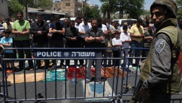 فلسطينيون يؤدون الصلاة خلف حاجز للجيش الاسرائيلي خارج المدينة القديمة في القدس 
