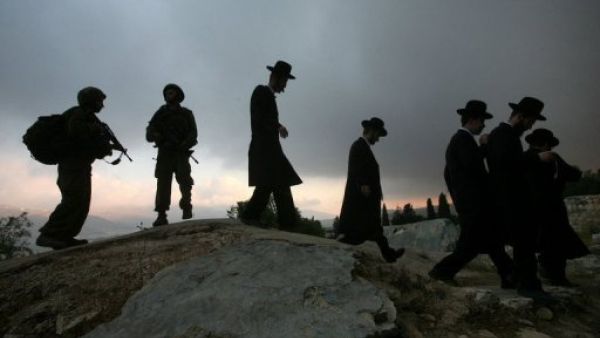 يهود متشددون يتوجهون للصلاة وسط حراسة من الجيش الاسرائيلي في الضفة الغربية  
