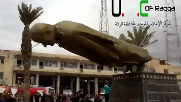 An image grab taken from a video uploaded on YouTube shows Syrian anti-regime protesters destroying a statue of former president Hafez al-Assad after rebels overran the northern city of Raqqa on Monday. (Photo: AFP Photo / YouTube)