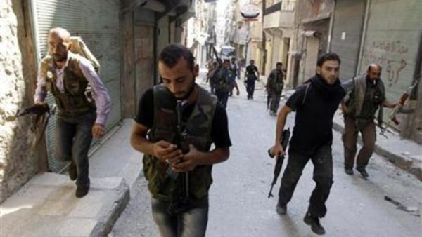 مقاتلون من الجيش السوري الحر بشارع في حي صلاح الدين في حلب 