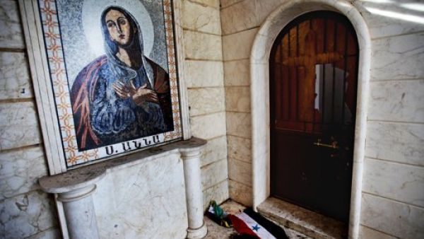 العلم السوري ملقى امام كنيسة سانتا انا في ادلب التي كان الجيش السوري قد حولها الى ثكنة عسكرية