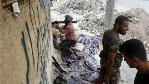 مقاتل من الجيش السوري الحر يحمل قذيفة صاروخية في احد شوارع حلب
