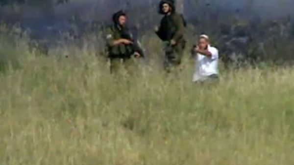 صورة من شريط فيديو تم تحميله على يوتيوب تظهر مستوطنا يطلق النار من مسدس على قرويين فلسطينيين يرمون الحجارة 
