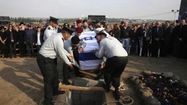 عسكريون اسرائيليون ينزلون جثمان شارون قبره في مزرعة أسرته بجنوب اسرائيل
