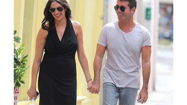 Hand in hand: Simon Cowell and girlfriend Lauren Silverman smile away as they stroll along on a lunch date. (Image: Facebook)