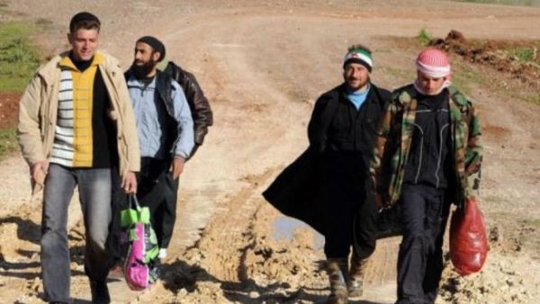 Syrian refugees walk down a dirt track in Antakya, Turkey, shortly after crossing into the country from Syria.