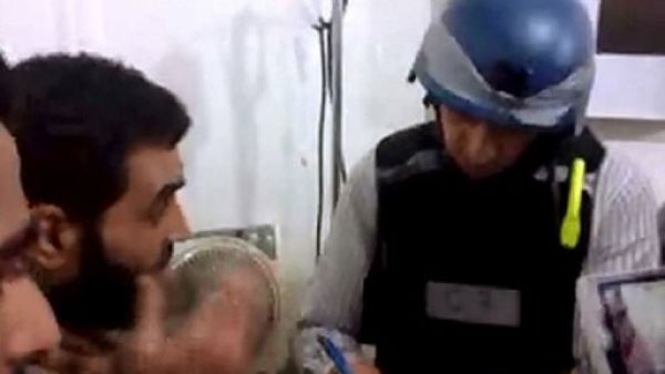 احد المفتشين يدون شهادة سوري في الهجوم الكيماوي بالغوطة