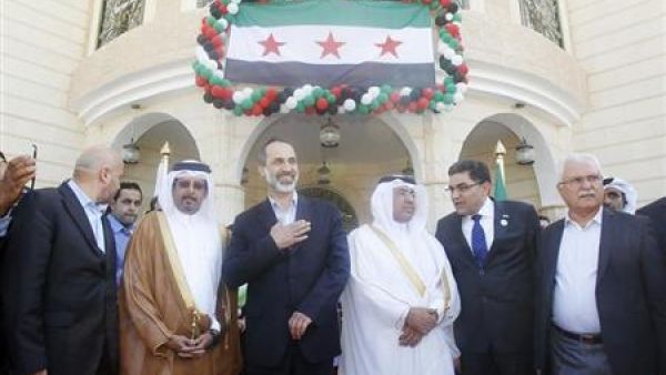 معاذ الخطيب (في الوسط) يحيي المشاركين في افتتاح سفارة الائتلاف الوطني السوري المعارض بالدوحة 