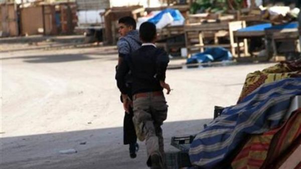 مدنيان يهربان من الاشتباكات في أحد أحياء مدينة طرابلس اللبنانية 