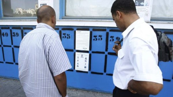 تونسيان يقرءان ملصقات انتخابية