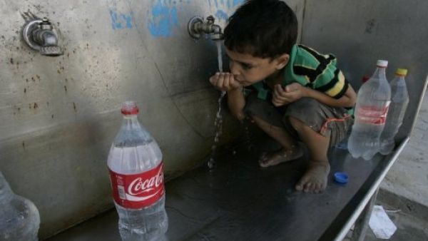 طفل فلسطيني يجلس امام صنبور عام للمياه