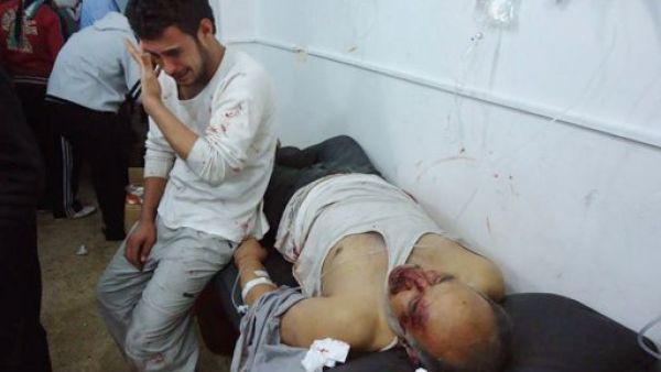 رجل يبكي بجوار جثة رجل اخر قتلته القوات السورية في حمص