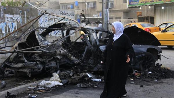 امراة تتفقد موقع تفجير انتحاري وقع السبت في بغداد وكان شقيقها من ضمن ضحاياه
