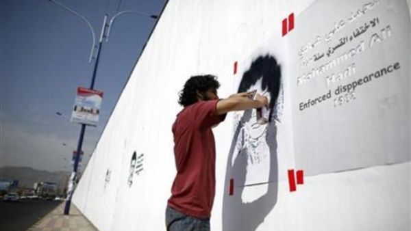 يمنيون يرسمون صور نشطاء اختفوا على جدران شوارع صنعاء 