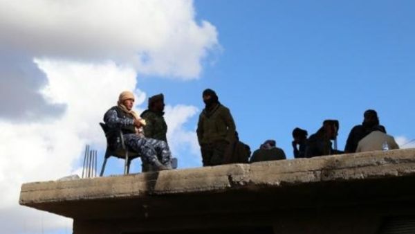 مقاتلون من قوات سوريا الديموقراطية فوق سطح في بلدة الباغوز الفوقاني في ريف دير الزرو في شرق سوريا
