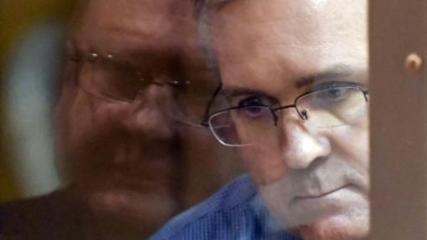 عنصر المارينز السابق بول ويلان ينظر من خلف قفص زجاجي خلال محاكمته في قاعة محكمة في موسكو

