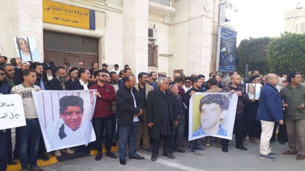 المتظاهرون رفعوا صور السنوسي خلف قضبان ولافتات كُتب عليها "الحرية للسجناء، نعم للمصالحة الوطنية"
