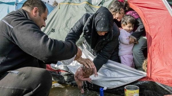 لاجئة سورية تحمم رضيعتها في ظل ظروف جوية قاسية