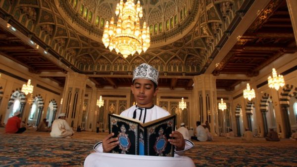 A boy reads the Qur'an inside the Sultan Qaboos Grand Mosque in Oman's capital city Muscat.  (AFP/Mohammed Mahjoub) 