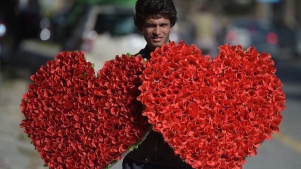 A Pakistani vendor carries heart-shaped bouquets for sale ahead of Valentine's Day along a street in Islamabad on February 13, 2017. (AFP)
