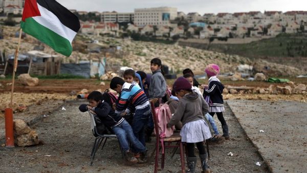Palestinian bedouin children from the Abu Nawar community attend a class in the West Bank town of al-Azariya near the Jewish settlement of Maale Adumim (background), east of Jerusalem, on February 23, 2016. (AFP/Ahmad Gharabli)