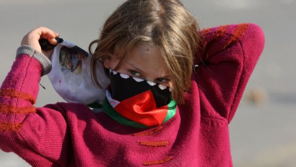 A Palestinian girl wraps a scarf around her face to protect from tear gas. (AFP/File)