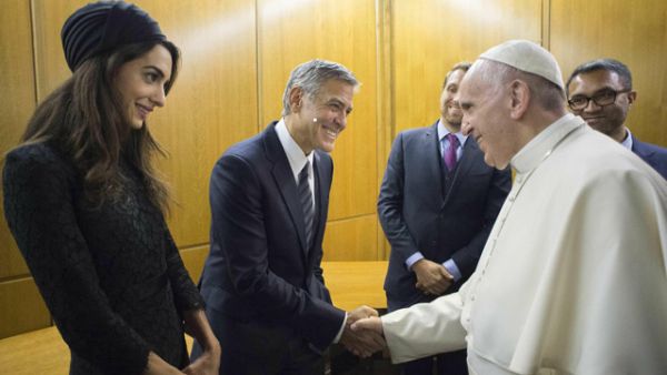 Pope Francis shaking hands with US actor George Clooney and his wife Amal Clooney prior a meeting with the participants of the Sixth World Congress of Pontifical Foundation Scholas Occurrentes. (AFP)