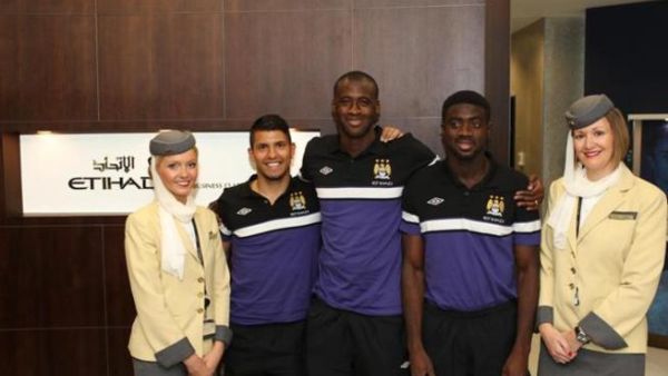 Manchester City Football Club team members Sergio Aquero, Yaya Toure and Kolo Toure flanked by Etihad Airways Business Class Lounge attendants at Manchester Airport before boarding their flight to Beijing Manchester City Football Club team members Sergio Aquero, Yaya Toure and Kolo Toure flanked by Etihad Airways Business Class Lounge attendants at Manchester Airport before boarding their flight to Beijing