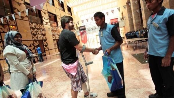CMUQ students handing the bags to the workers