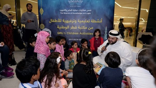 أطفال يستمعون إلى قصة قدمتها مكتبة قطر الوطنية خلال مهرجان "منارة العلم والتنوير"