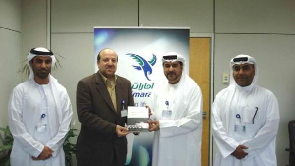 Abdulrahman Qassim Al Ali, Commercial Sales Manager at Emarat, receiving the book from its author in the presence of Salem Bin Suloom and Nassar bin Nassar