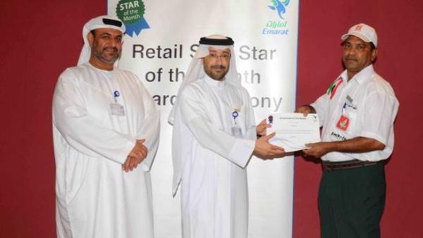 Abdulla Hassan Al Noman, Manager, Retail Sales Operations at Emarat honoring one of the employees