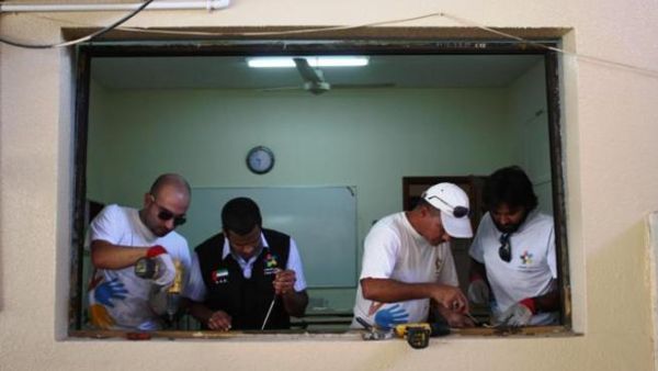 Dubai Cares volunteers installing new windows at Manar Al Iman Private School in Ajman