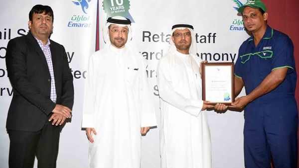 Abdulraoof Abdulaziz honors a staff member in the presence of Abdulla Hassan Al Noman and Ali Khan