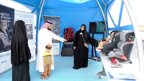 Kulluna volunteers explain importance of child car seat to visitors
