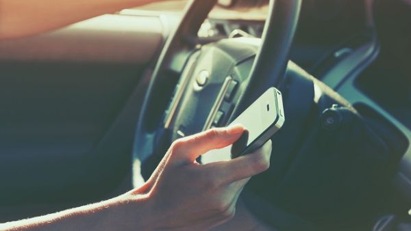 Even touching your mobile phone while driving will be considered a traffic violation for which motorists will be fined SR150. (Shutterstock)