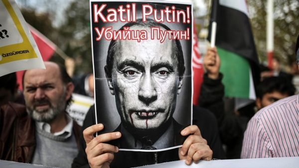 A protester holds a poster depicting Russian President Vladimir Putin and reading “Putin, killer!” during a demonstration in Istanbul, on November 27, 2015. (AFP/ Cagdas Erdogan)