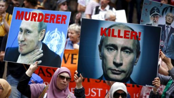 متظاهرون في العاصمة الاسترالية سيدني يحملون صورا كتبت عليها عبارات تندد بالرئيس الروسي على خلفية تدخل بلاده العسكري في سوريا
