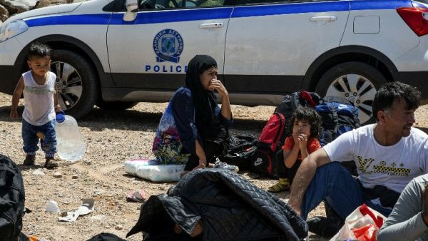 Refugees and migrants wait by a police car in Crete, after being rescued from another capsized vessel on May 31. (AFP/Stringer) Refugees and migrants wait by a police car in Crete, after being rescued from another capsized vessel on May 31. (AFP/Stringer)