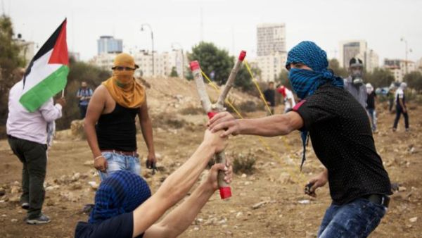 Palestinians prepare to launch a rock from a homemade slingshot during clashes with Israeli soldiers. (AFP/FIle) Palestinians prepare to launch a rock from a homemade slingshot during clashes with Israeli soldiers. (AFP/FIle)