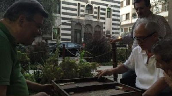 Tourist shop owners play backgammon on Damascus Straight Street (TCF)