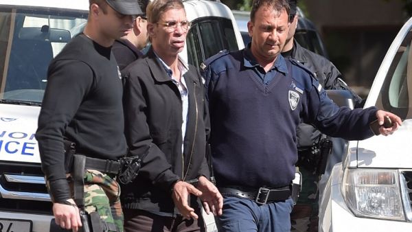 Seif al-Din Mohamed Mostafa, an Egyptian man who hijacked an EgyptAir passenger plane and forced it to divert to Cyprus demanding to see his ex-wife, wears handcuffs as he leaves court in Larnaca escorted by Cypriot police on March 30, 2016. (AFP/George Michael)