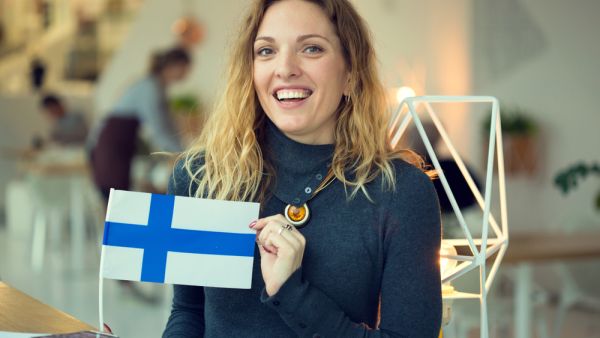 woman holds the flag of Finland. (Shutterstock/ File Photo)