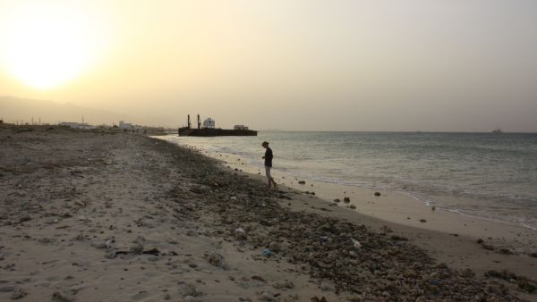 Girl standing at a polluted beach at sunset at the coast of Oman. (Shutterstock/ File)