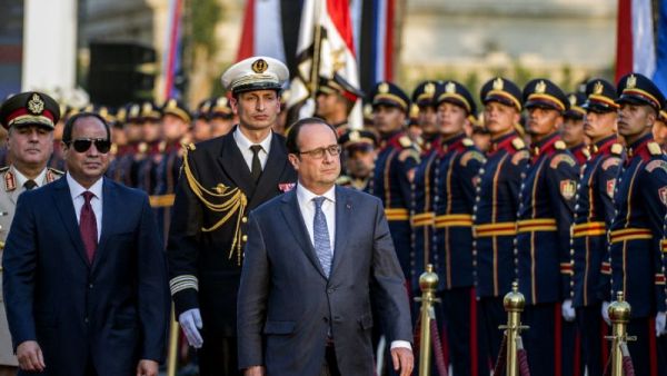 Egyptian President Abdelfattah al-Sisi and his French counterpart Francois Hollande review the honour guard during a welcome ceremony at the al-Quba presidential palace in Cairo on April 17, 2016. (AFP/Khaled Desouki)